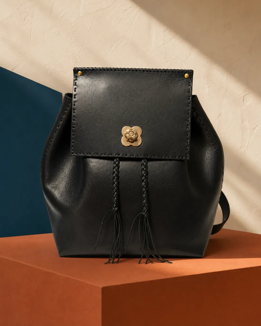 Zaino Aundrey OSA in pelle di vitello nera con chiusura a fiore e nappine intrecciate