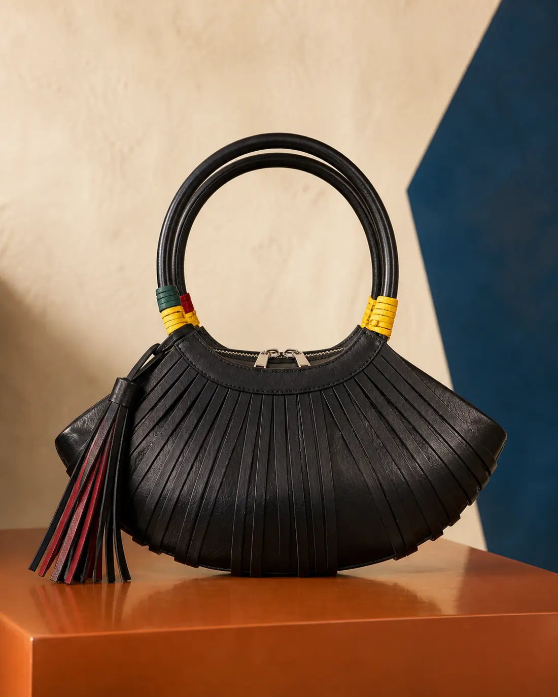 Borsa Kora OSA a mezzaluna in pelle nera con radiali a ventaglio, manici ad anello e nastri colorati